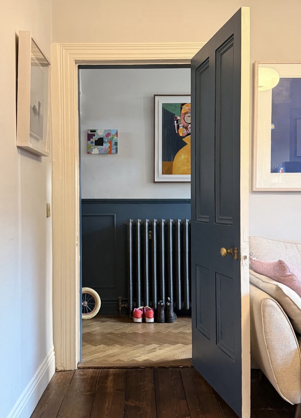 Hallway view with framed artwork beside a door
