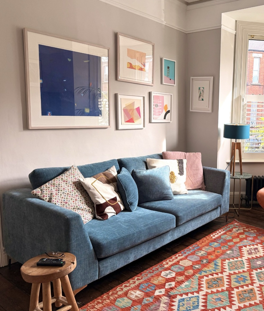 Sitting room gallery wall above a blue sofa